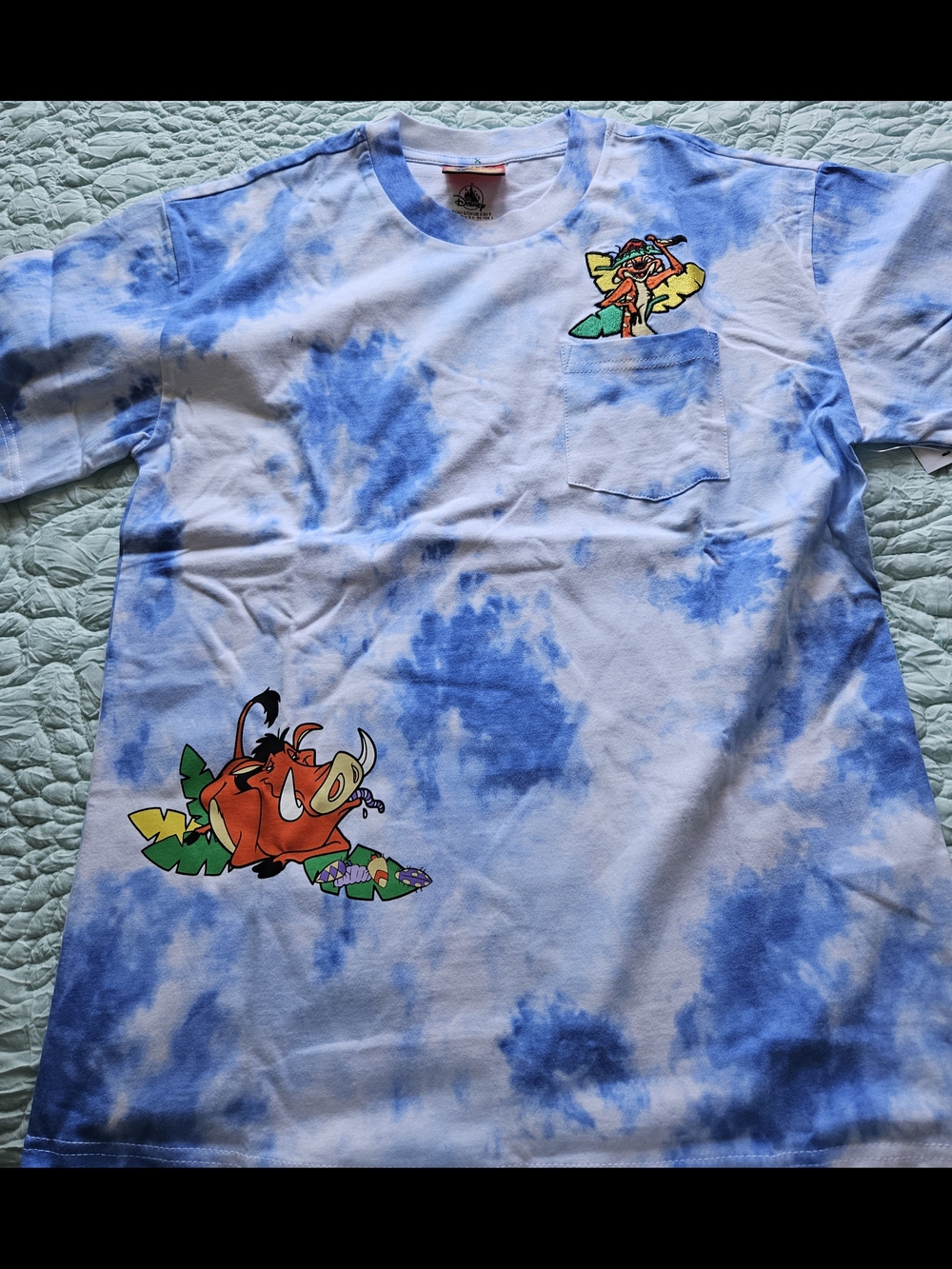 NEW adults’ pocket T-shirt features a blue and white tie-dye pattern, with art